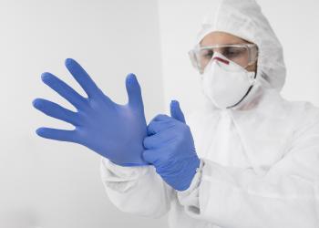 Homme masqué portant des gants de protection chimique