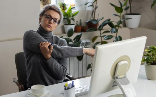 Personne souffrant de douleurs au bras devant son écran